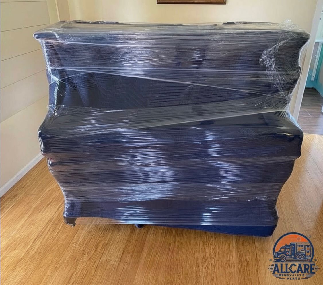 Upright piano fully wrapped with protective blankets and plastic wrap by AllCare Removalists Perth during a professional moving service.