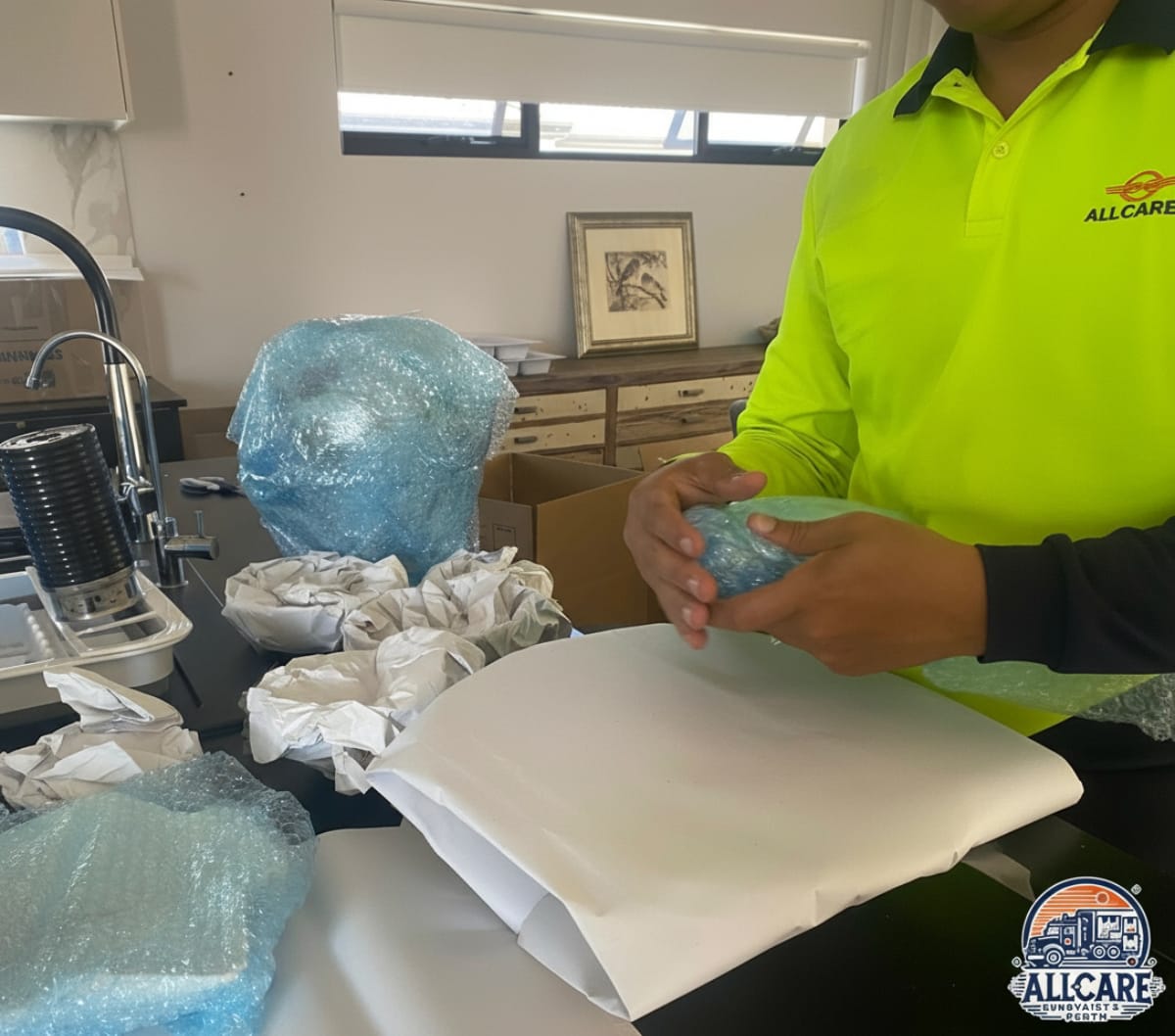AllCare Removalists Perth staff carefully wrapping fragile household items with bubble wrap — professional packing service in Perth.