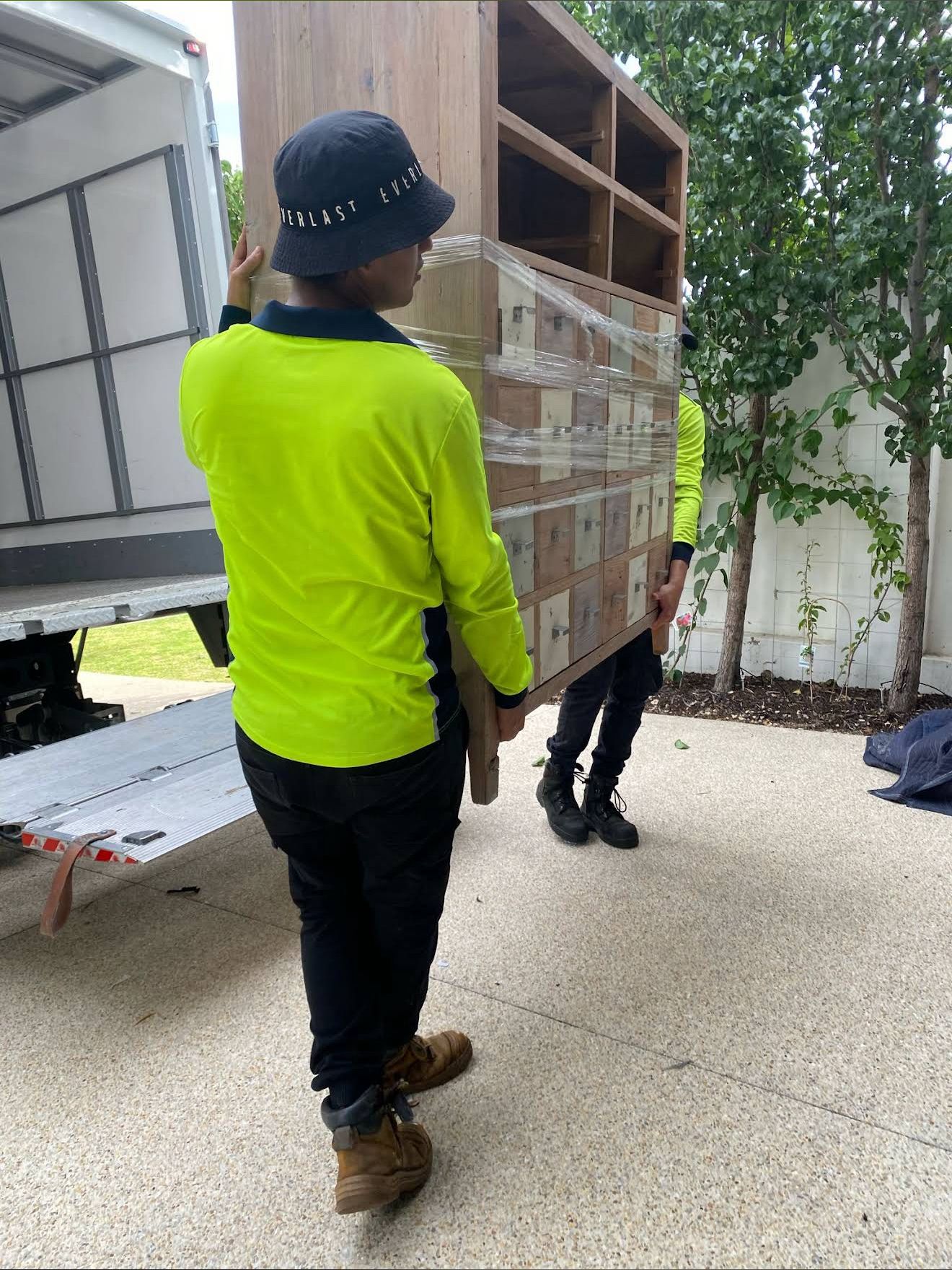 Professional movers in Perth loading heavy wooden furniture into a removals truck – AllCare Removalists expert team providing safe, reliable moving services