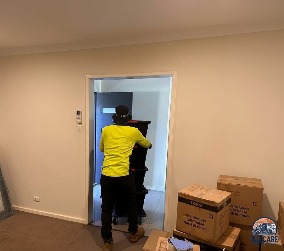 Professional removalist from AllCare Removalists Perth moving packed boxes into a home, demonstrating safe and efficient residential moving services.